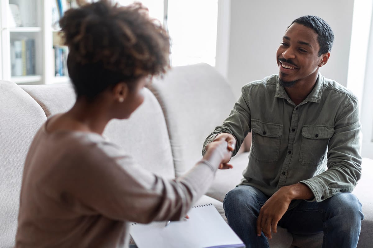 Client and counselor shaking hands in treatment session at QuickSilver Counseling Center