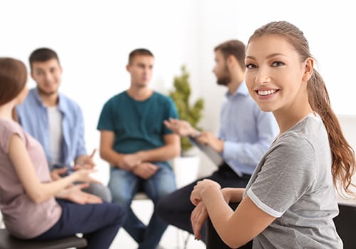 Happy person in group therapy in an alcohol addiction treatment program