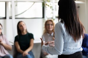 Person standing and peaking in front of a group in an opioid addiction treatment program