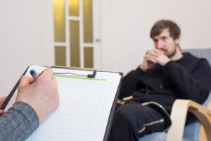 a therapist takes notes while listening to a patient in a Heroin Addiction Treatment Program