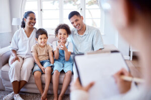 a family smiles at a therapist during a family therapy program