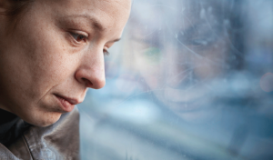 a person looks sadly from a window after researching things you should know about heroin