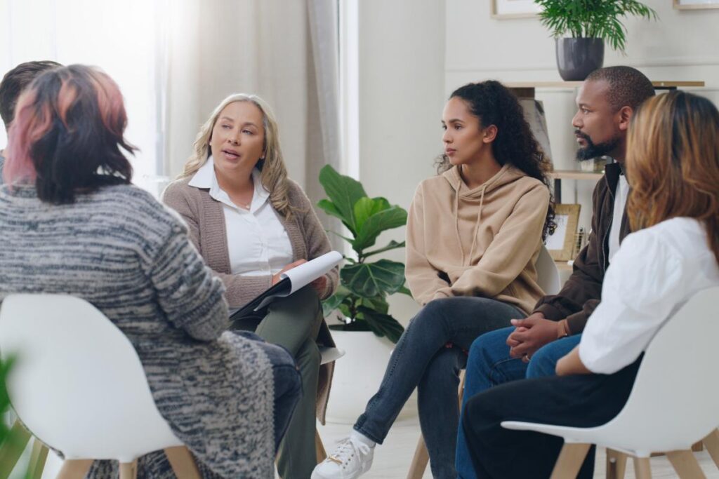 a therapist talks to a group about What to Expect in Group Therapy