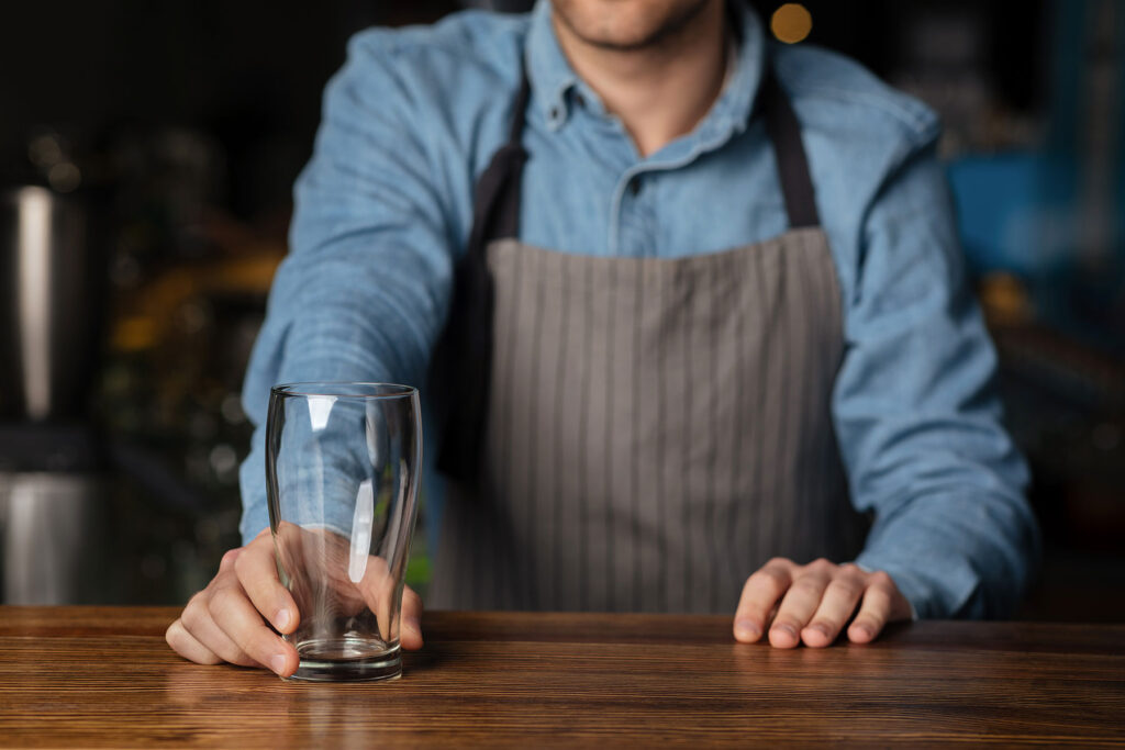 a bartender offers an empty glass after recognizing alcoholism signs