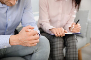a therapist takes notes while listening to a client in a new jersey alcohol addiction treatment center